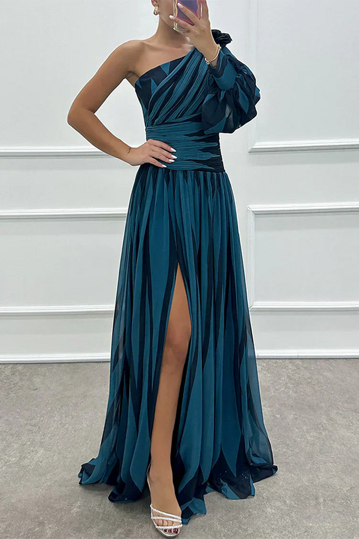Woman wearing a striped maxi dress with graceful drape against a plain background.