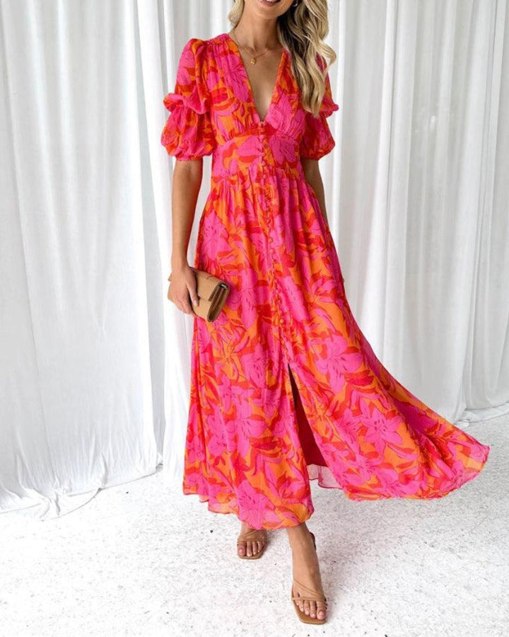 Woman wearing a V-neck maxi dress with puff sleeves against a plain background.