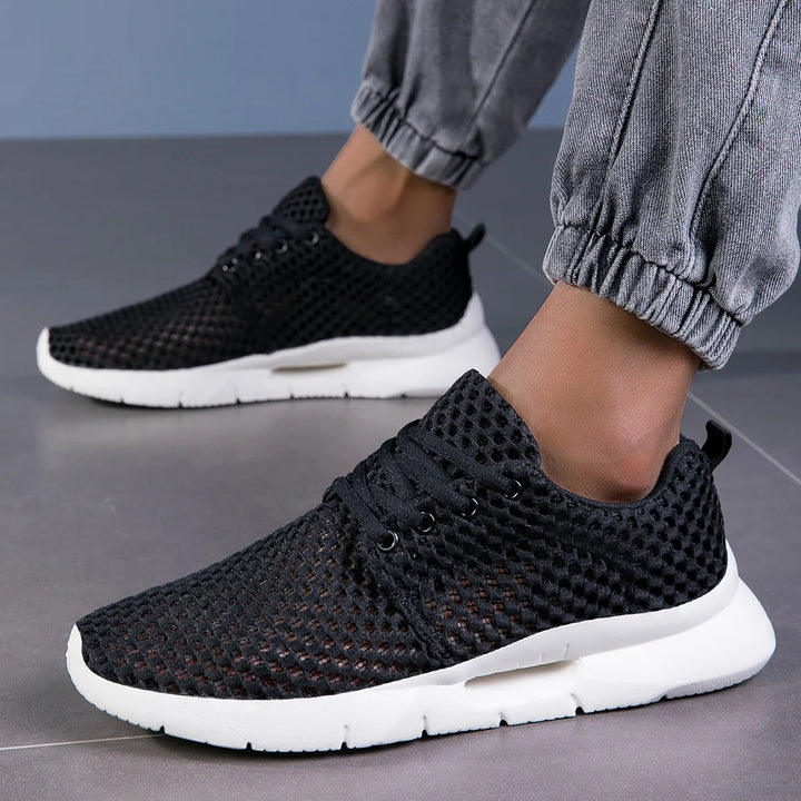 Side view of women’s low-top sneakers on a plain background.
