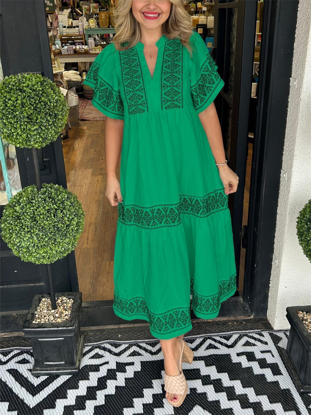Woman posing in a loose flowing dress on a neutral background.