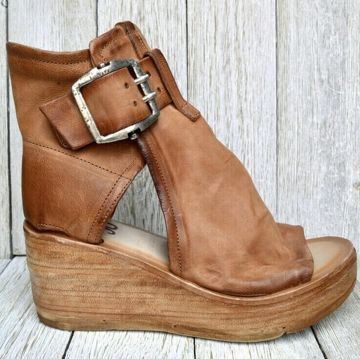 Comfortable wedge sandals with buckle closure placed on a plain background.