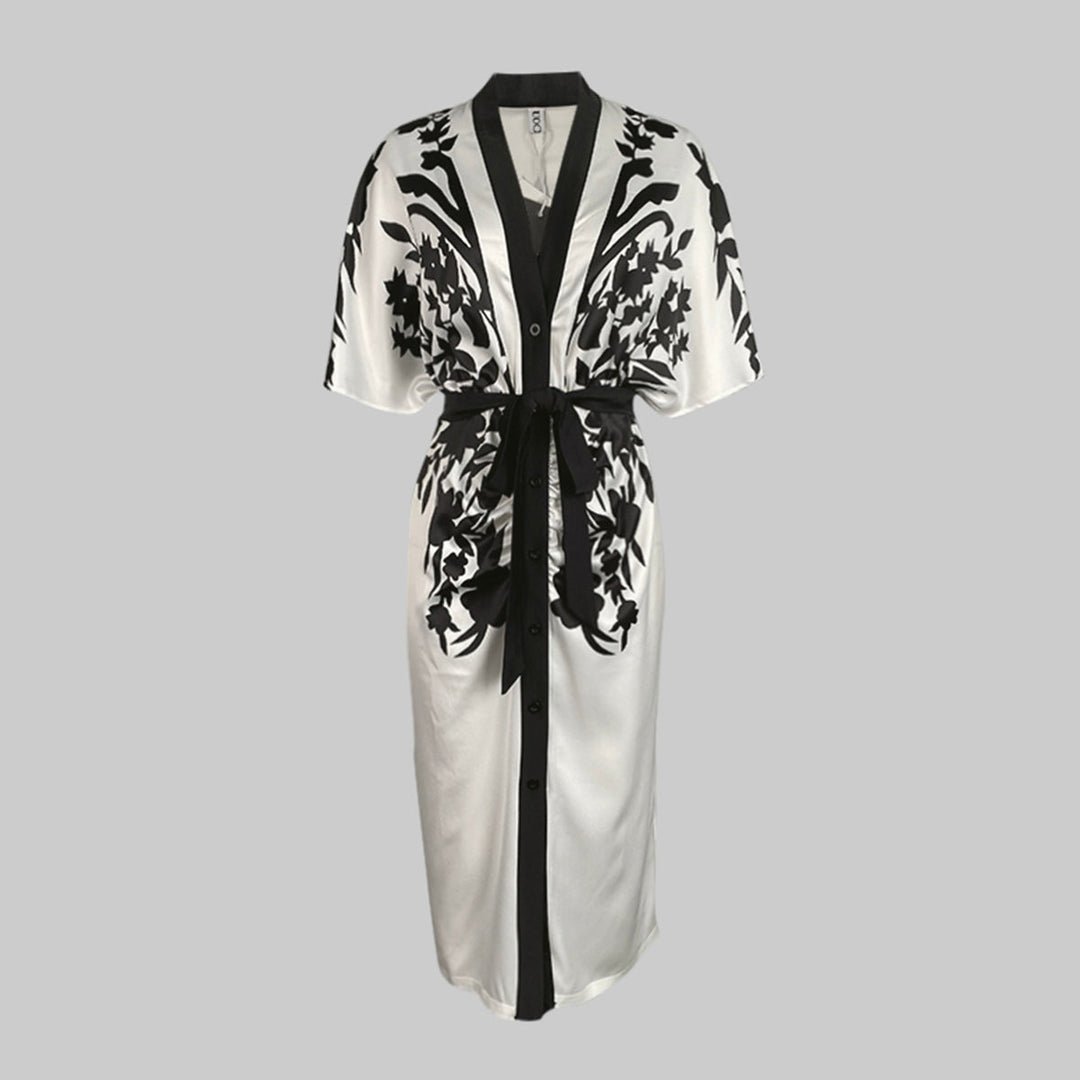 Deep V-neck floral midi dress with a waist tie and flowing silhouette on a plain background.