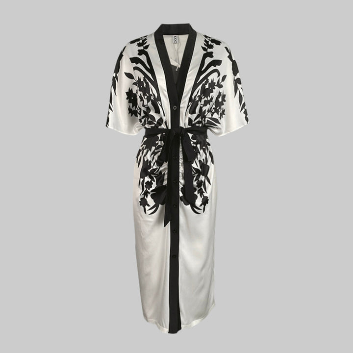 Deep V-neck floral midi dress with a waist tie and flowing silhouette on a plain background.