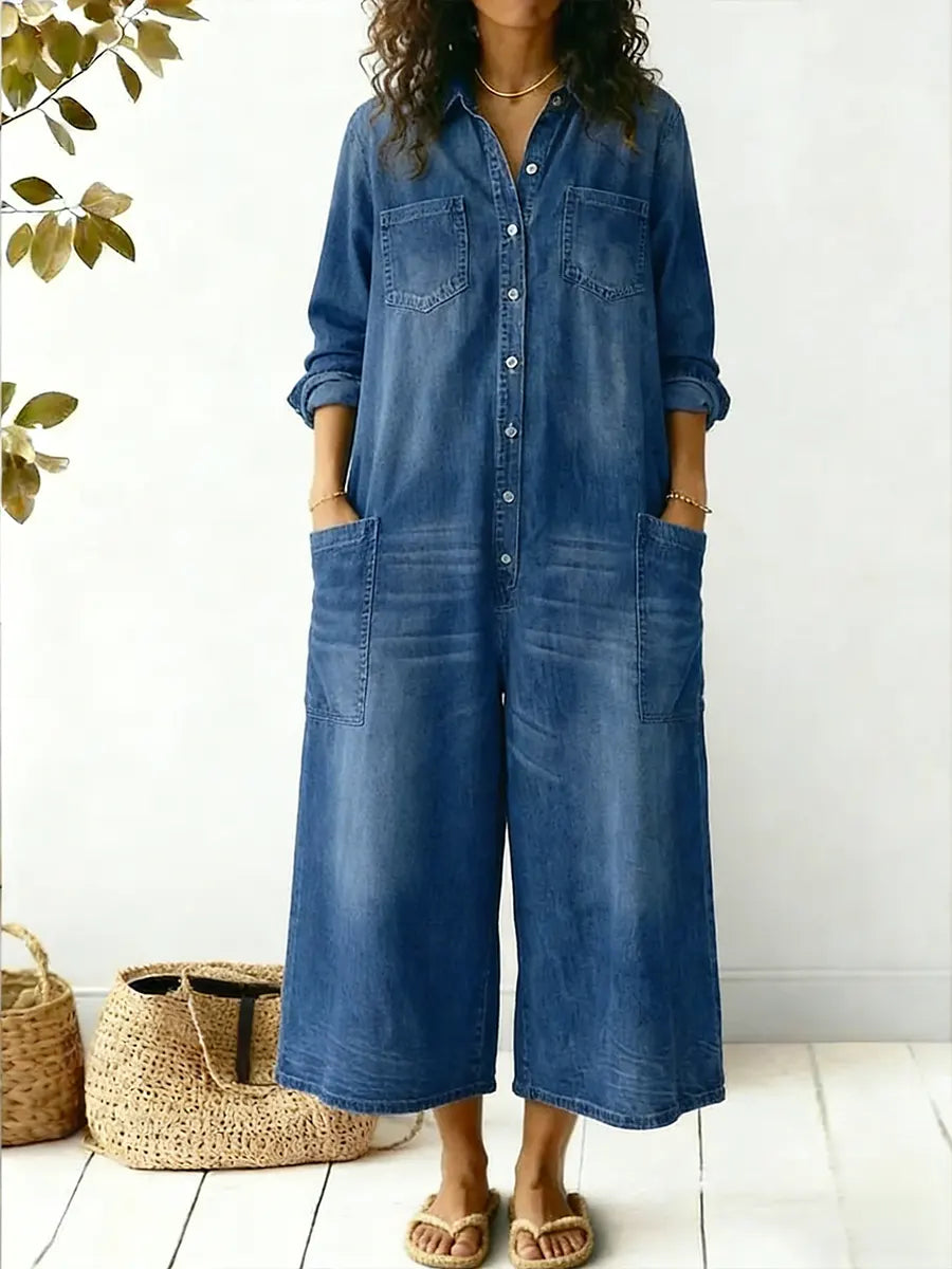 Woman wearing a button-front denim jumpsuit with chest pockets on a plain background