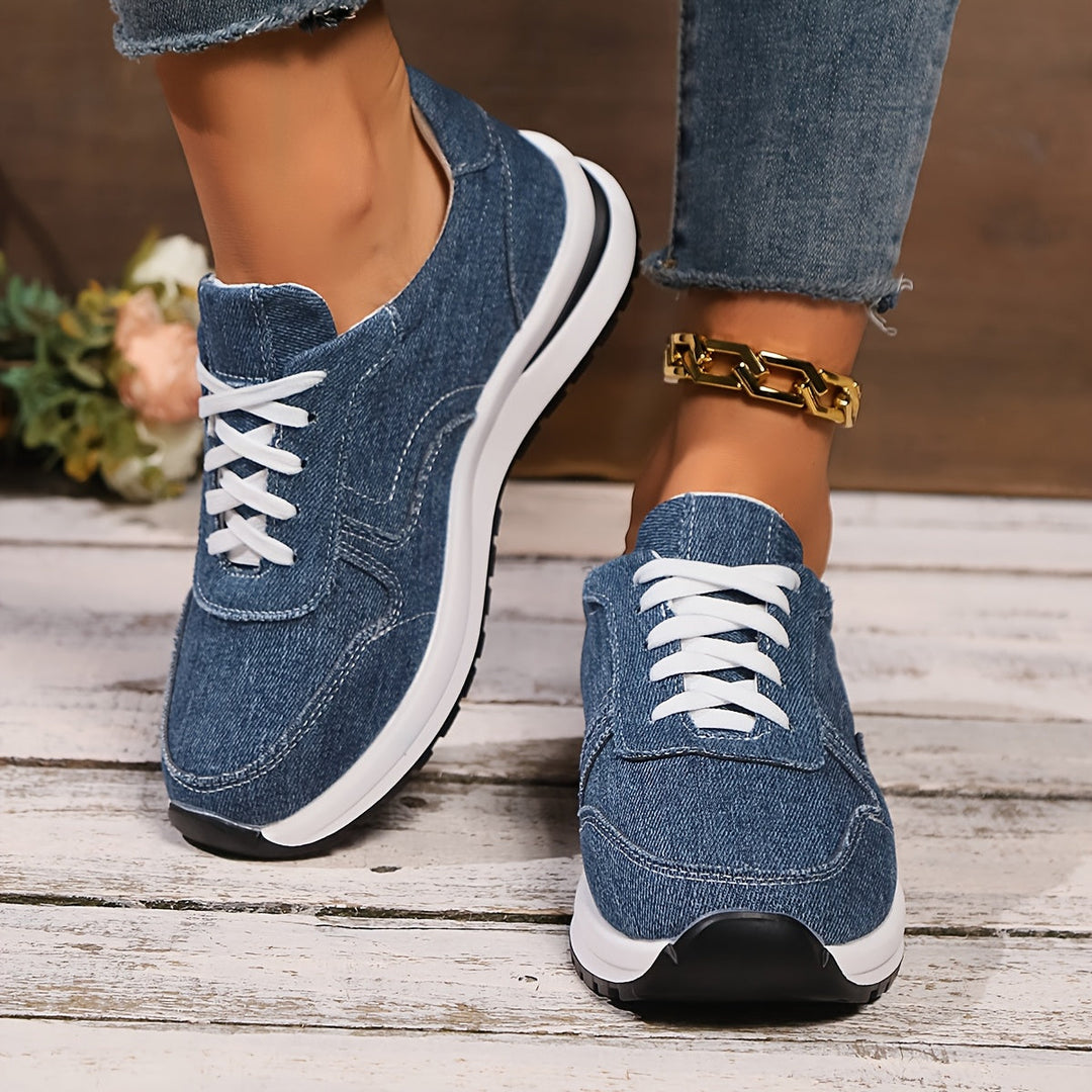 Women’s slip-on style sneakers with denim texture displayed on a plain background.