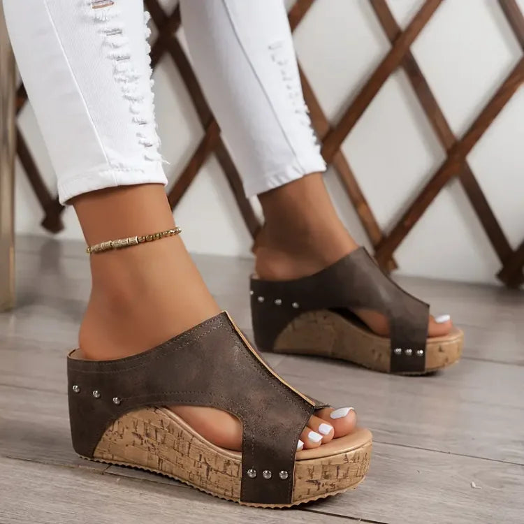 Feet shown only wearing adjustable strap orthopedic sandals on a plain background.