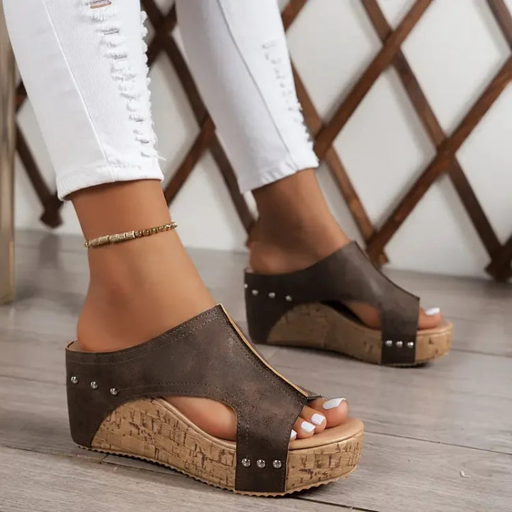 Feet shown only wearing adjustable strap orthopedic sandals on a plain background.
