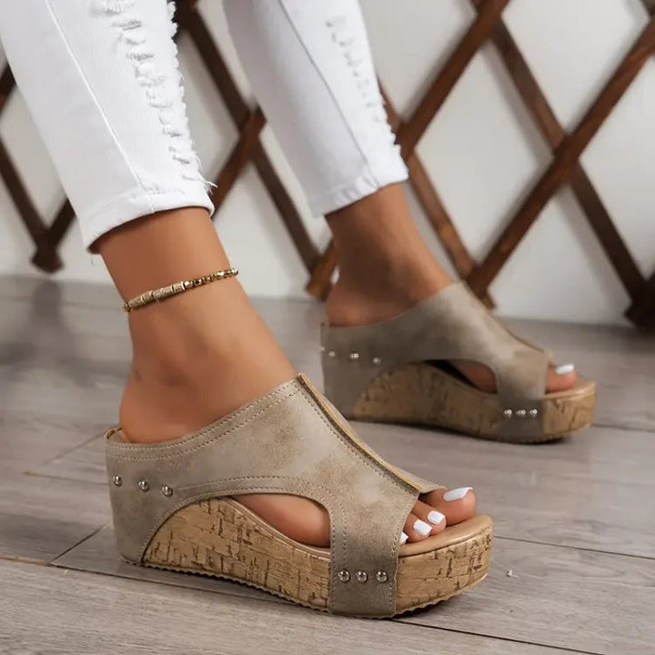 Women’s feet in comfortable cushioned sandals against a clean background.
