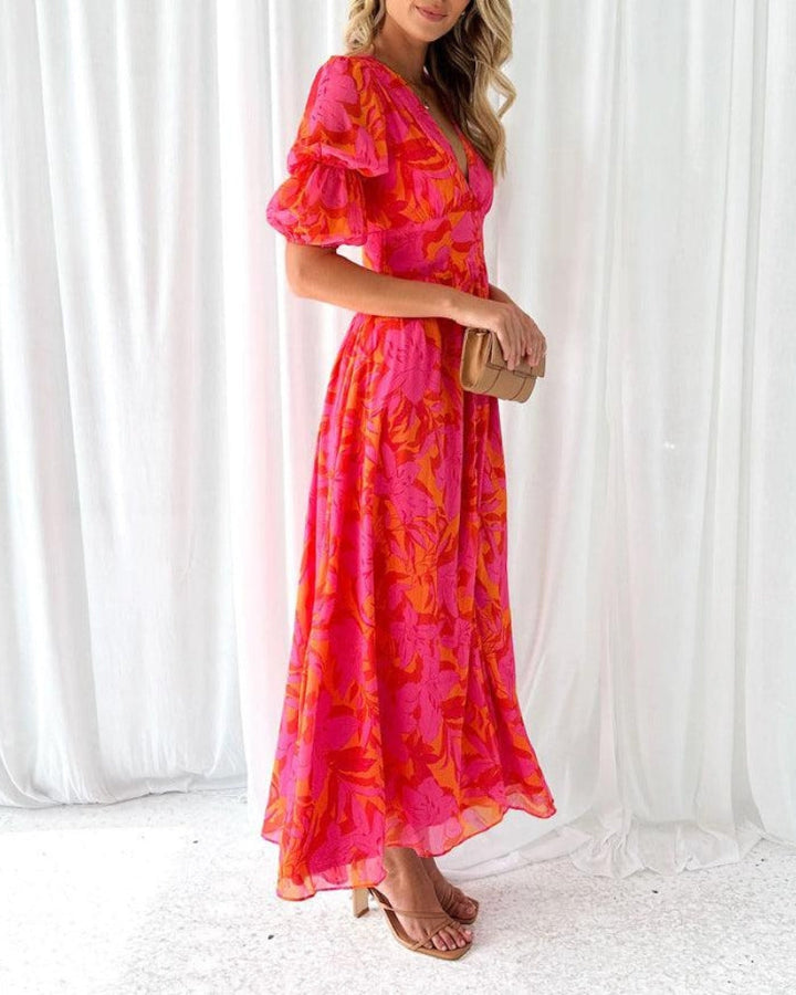 Female model in a flowing maxi dress with soft puff sleeves on a clean background.