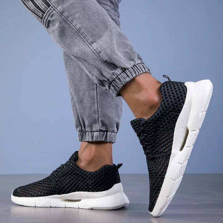 Female model displaying cushioned walking sneakers against a plain background.