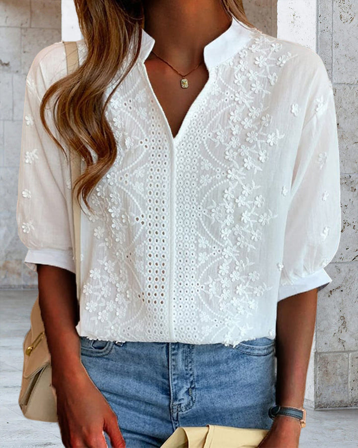 Detailed sleeve close-up of blouse on plain studio background.
