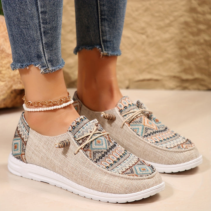 Feet in casual tribal design sneakers shown on a plain background.