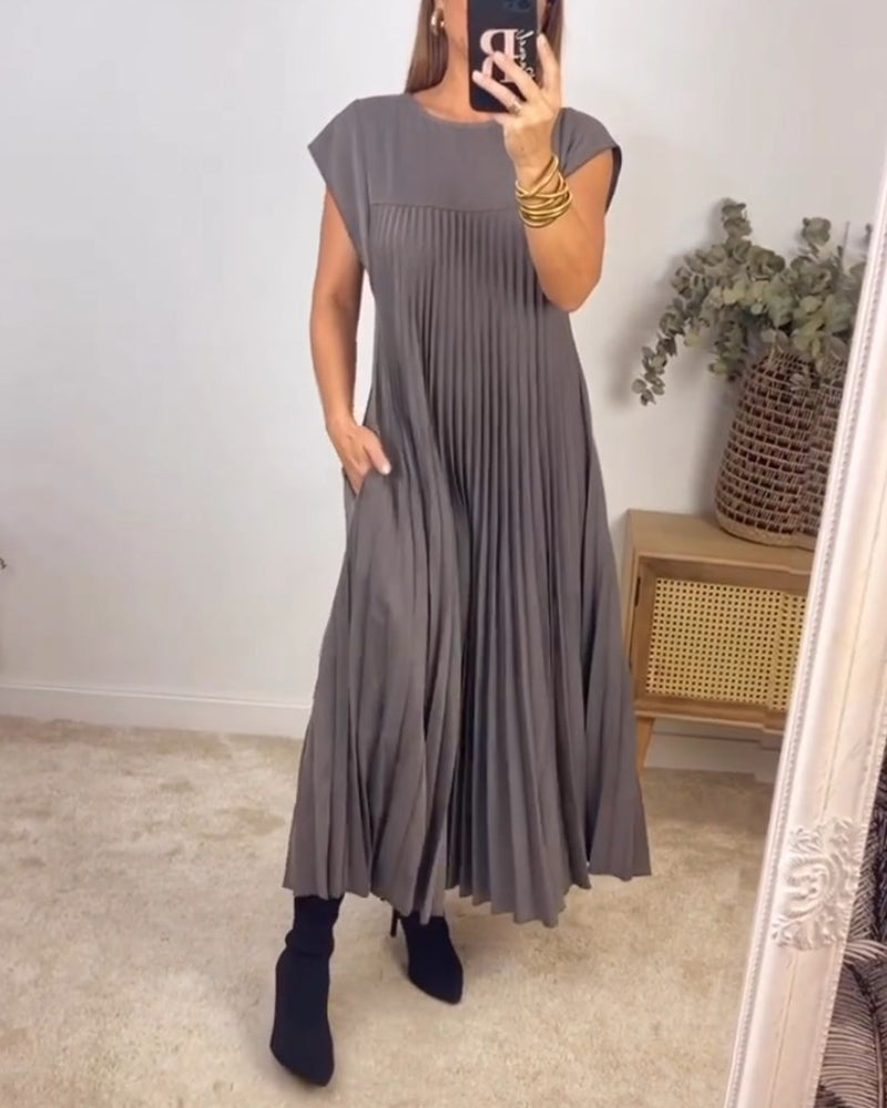 Long pleated cocktail dress displayed on a woman with a clean background.