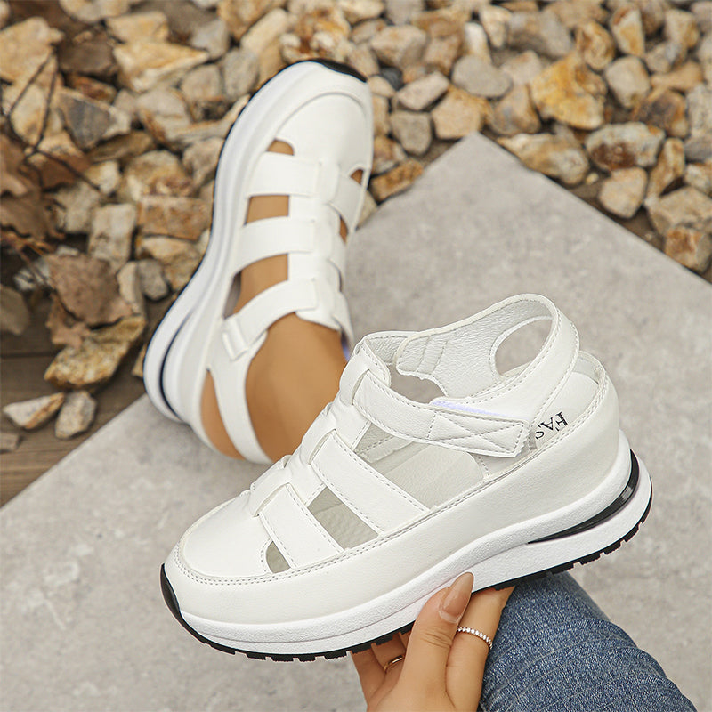 Model showing feet in white everyday sneakers on a plain backdrop.