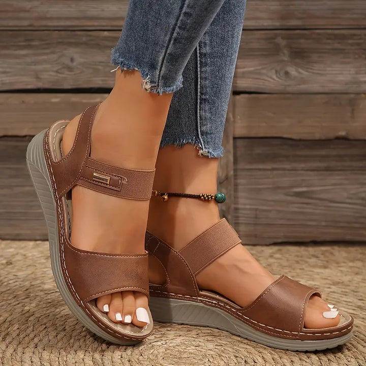 Close-up of feet in chic adjustable sandals against a clean background.
