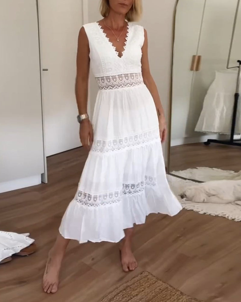 Woman wearing a flowing boho wrap dress on a plain background.