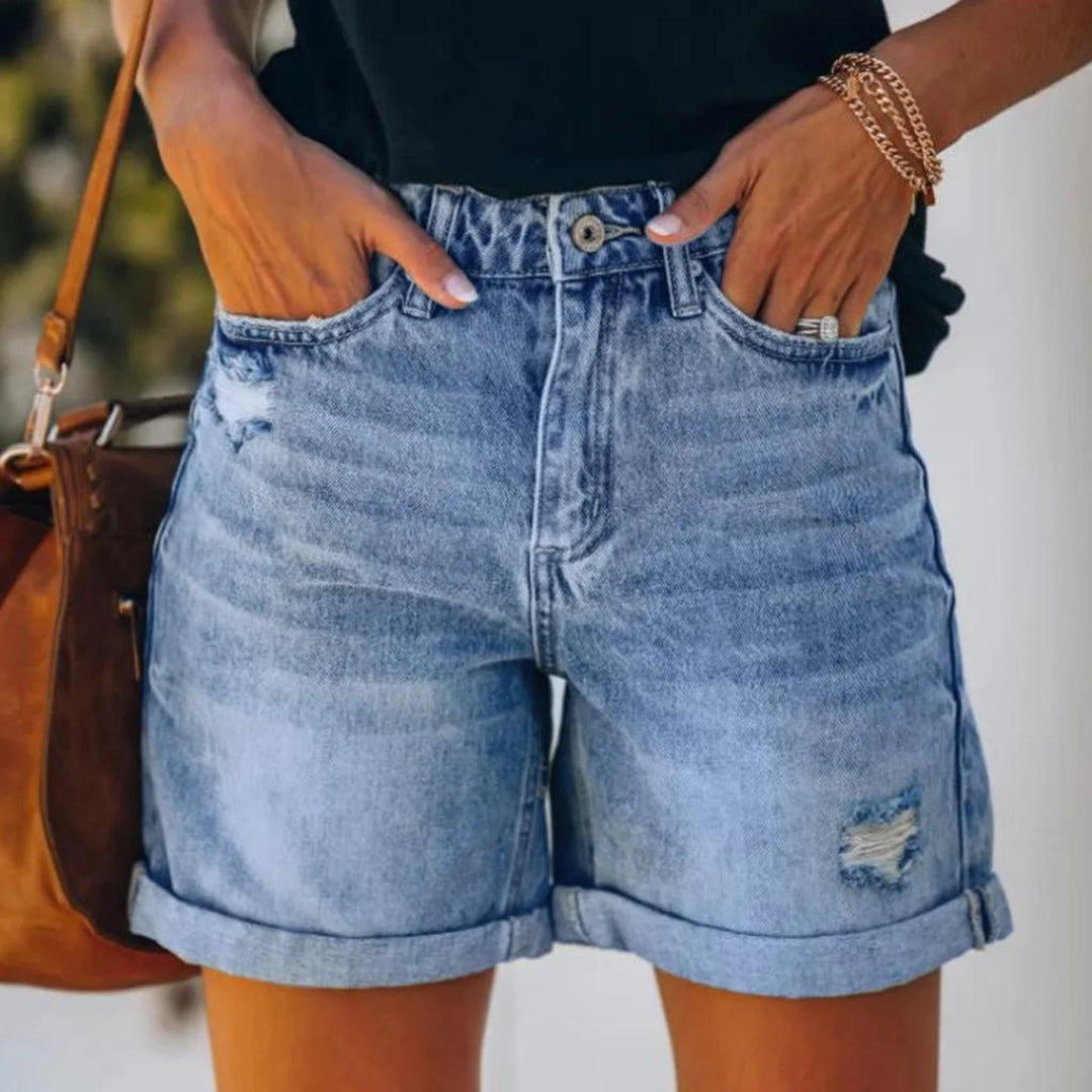 Woman wearing high waist ladies shorts on a plain background.
