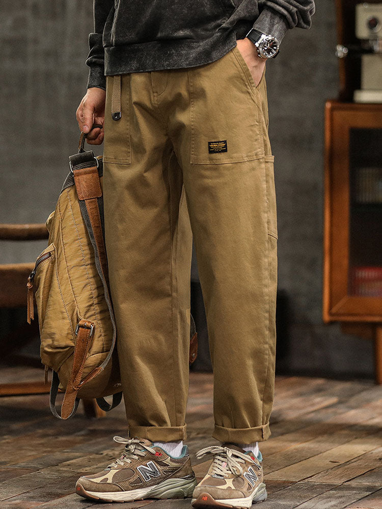  Male model in relaxed cargo pants designed for casual styling against a plain background.
