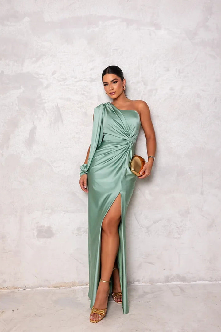 Female model posing in a lightweight maxi dress with a plain backdrop.