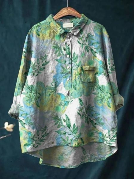 Feminine printed blouse on a plain background.