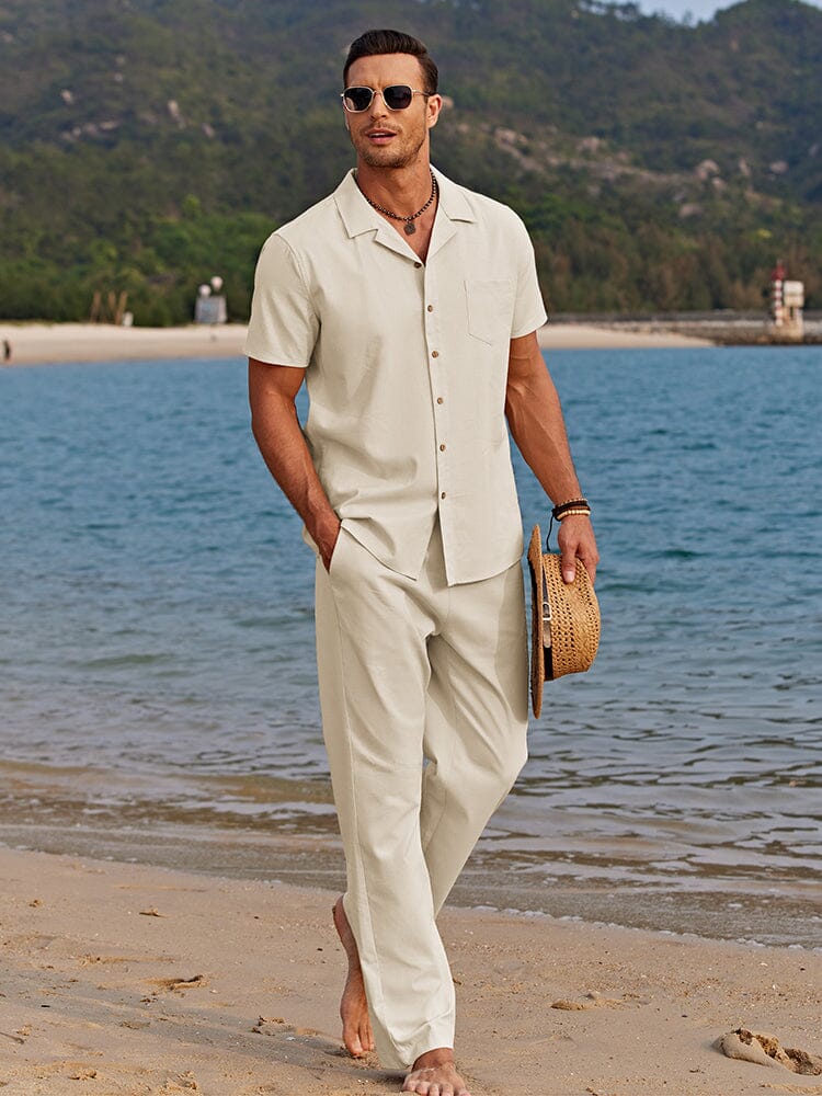  Man showcasing a coordinated button-up shirt and matching pants outfit on a plain background.