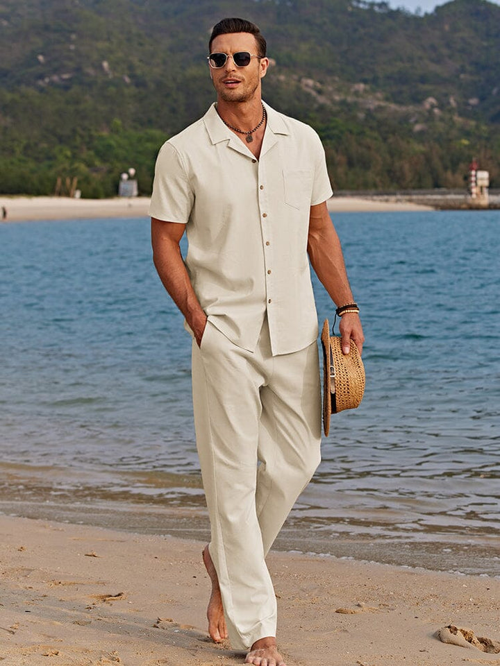  Man showcasing a coordinated button-up shirt and matching pants outfit on a plain background.
