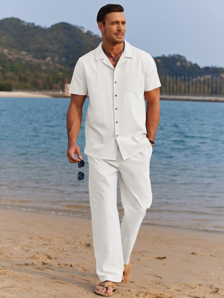  Man wearing a casual matching shirt and pants set on a plain background.