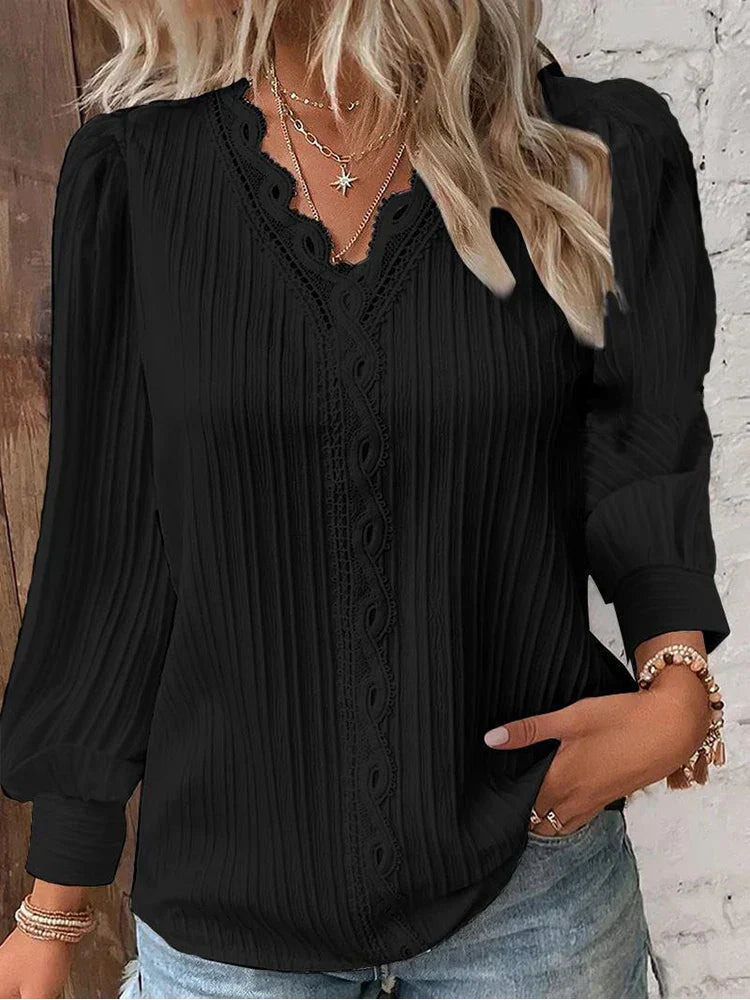 Elegant women’s blouse with flowing fabric and lace details worn in studio lighting.