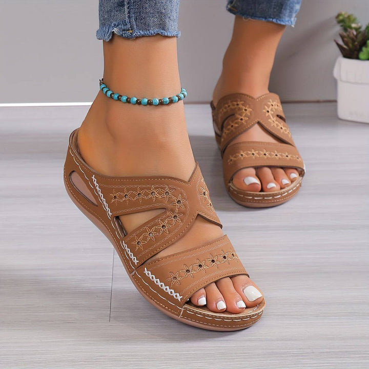 Female wearing everyday comfort sandals on a plain background.