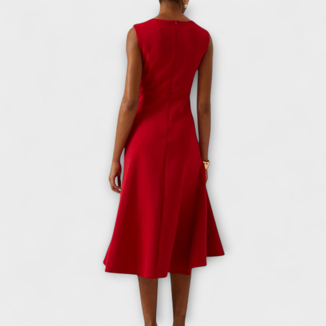 Woman posing in a flowing midi dress with elegant draped detailing, back view
