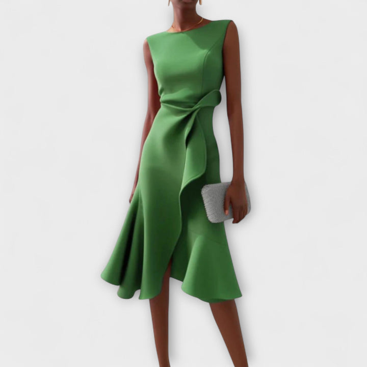 Female model wearing a stylish sleeveless party dress on a plain backgroun