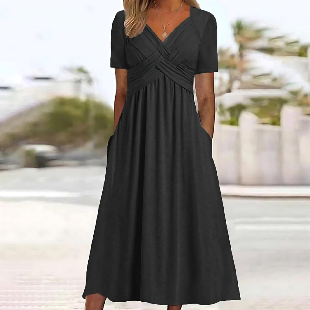 Female model in a flowing A-line midi dress on a plain background.