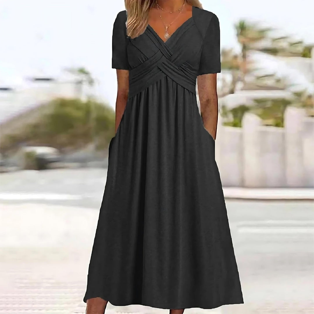 Female model in a flowing A-line midi dress on a plain background.