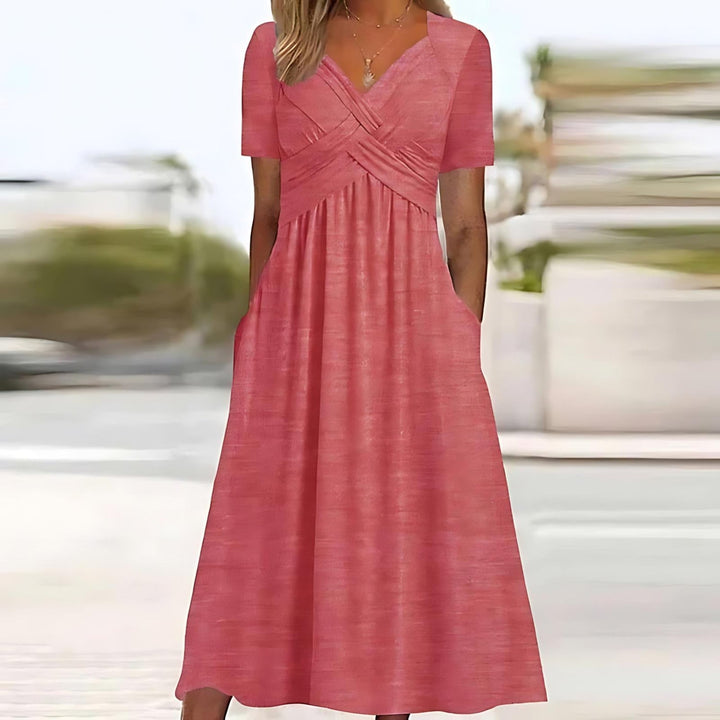 Female model showing a V-neck midi dress with a smooth drape on a plain background.