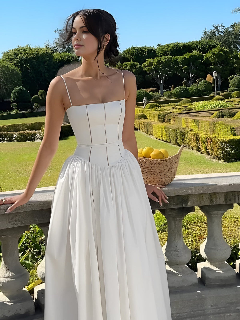 Female model wearing flowing midi dress with terrace background.