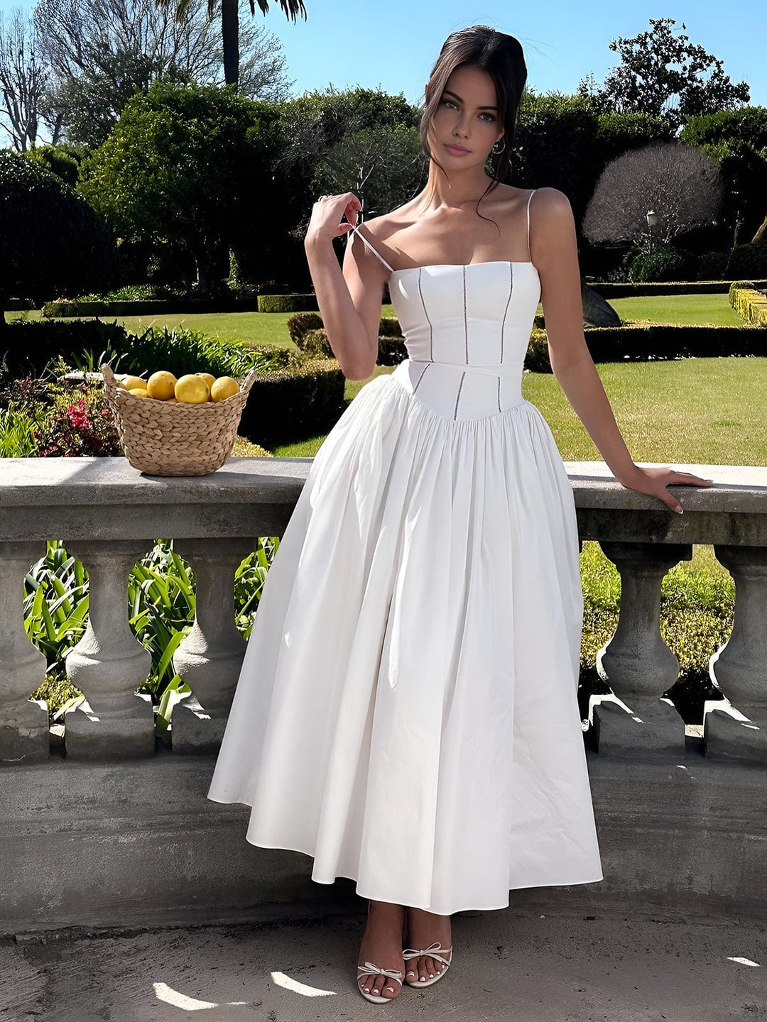 Woman standing in nature wearing graceful fitted bodice midi dress.