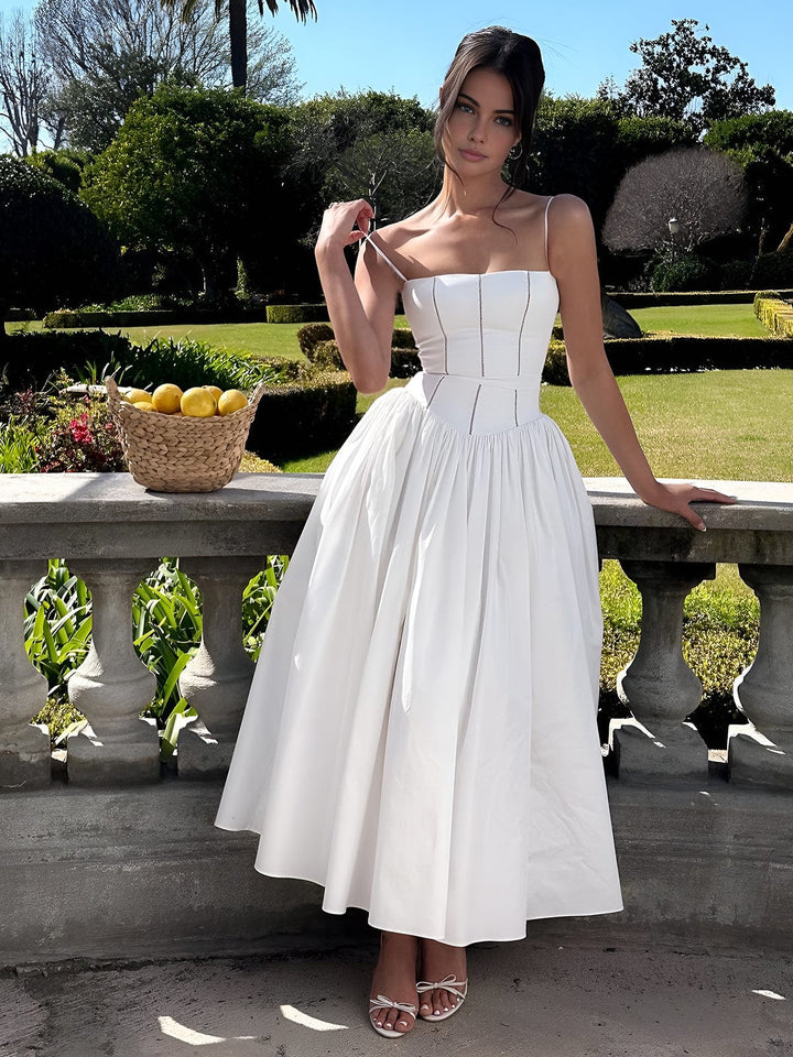 Woman standing in nature wearing graceful fitted bodice midi dress.