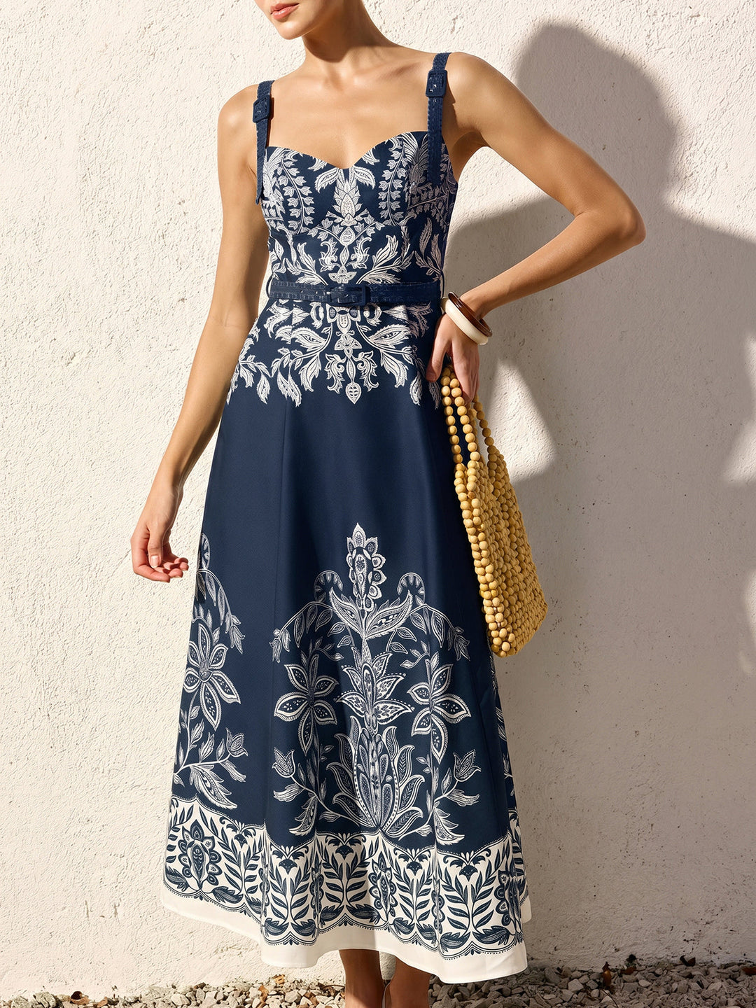 Woman styled in a square neck maxi dress against a plain backdrop.