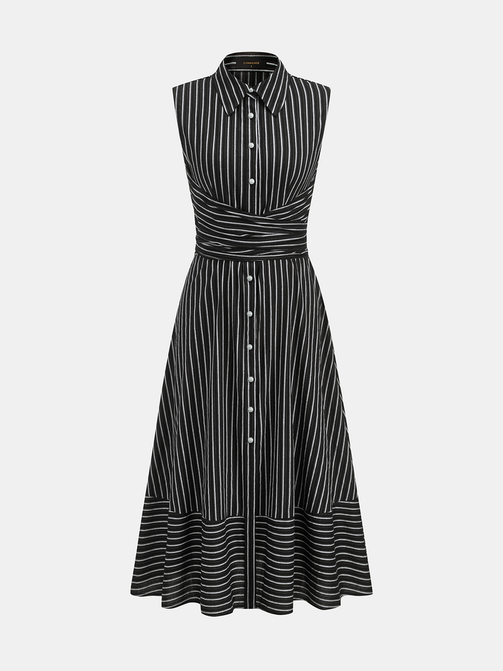 Woman standing in a sleeveless midi dress featuring a streamlined silhouette on a plain background.