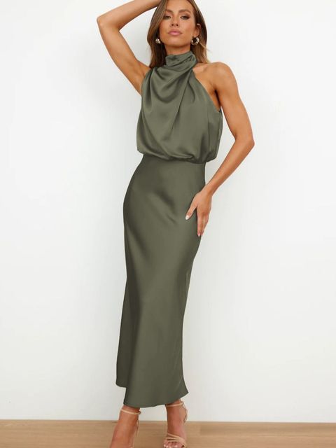 Model wearing a long off shoulder dress with a sleek silhouette on a plain background.