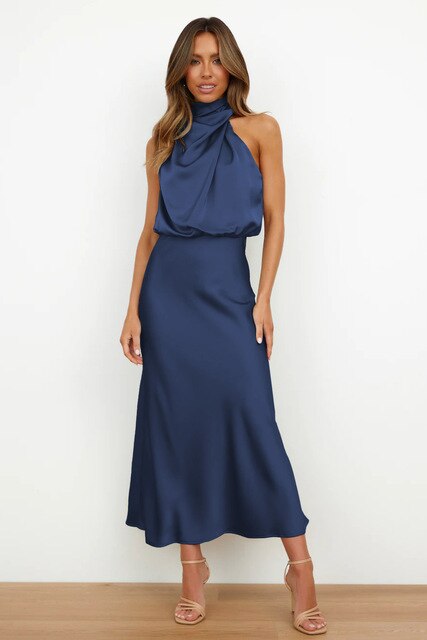 Woman showcasing a fitted long dress with bare shoulder styling on a plain background.