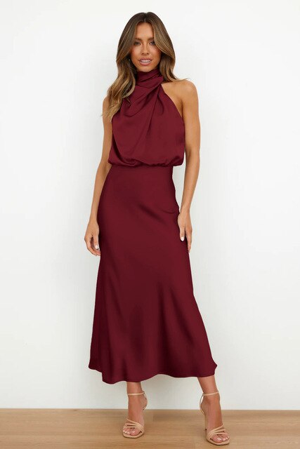 Model wearing an elegant off shoulder party dress on a plain background.