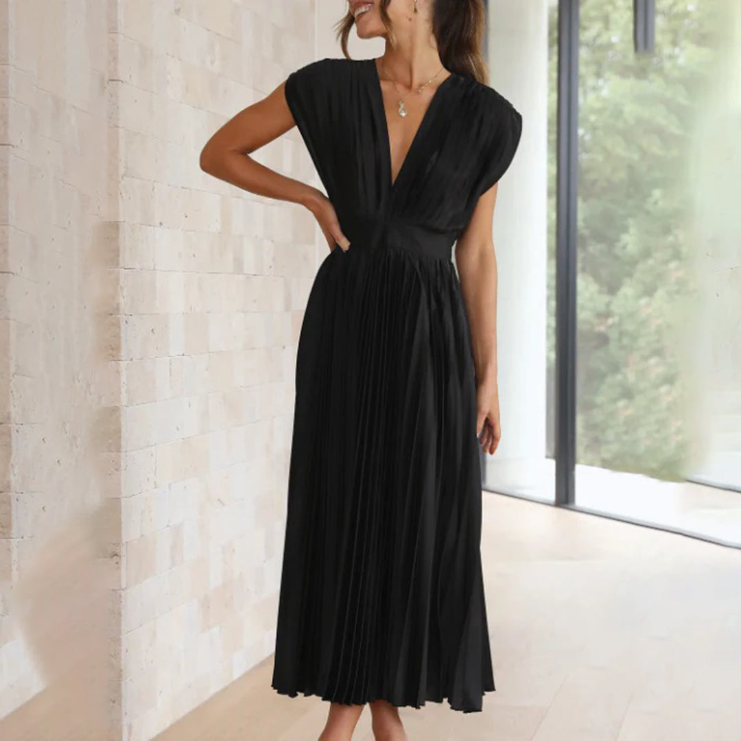 Female model wearing an elegant dress on a plain background.