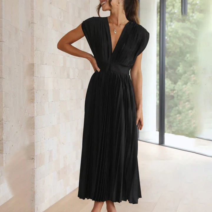 Female model wearing an elegant dress on a plain background.
