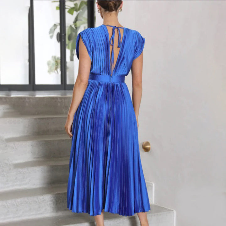 Model in a graceful dress standing on a plain background, view angle