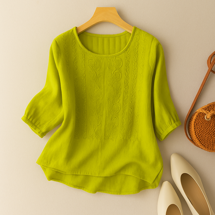 Feminine embroidered top shown with soft styling and clean background.