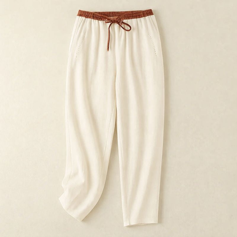 Woman wearing relaxed summer pants on a plain background.