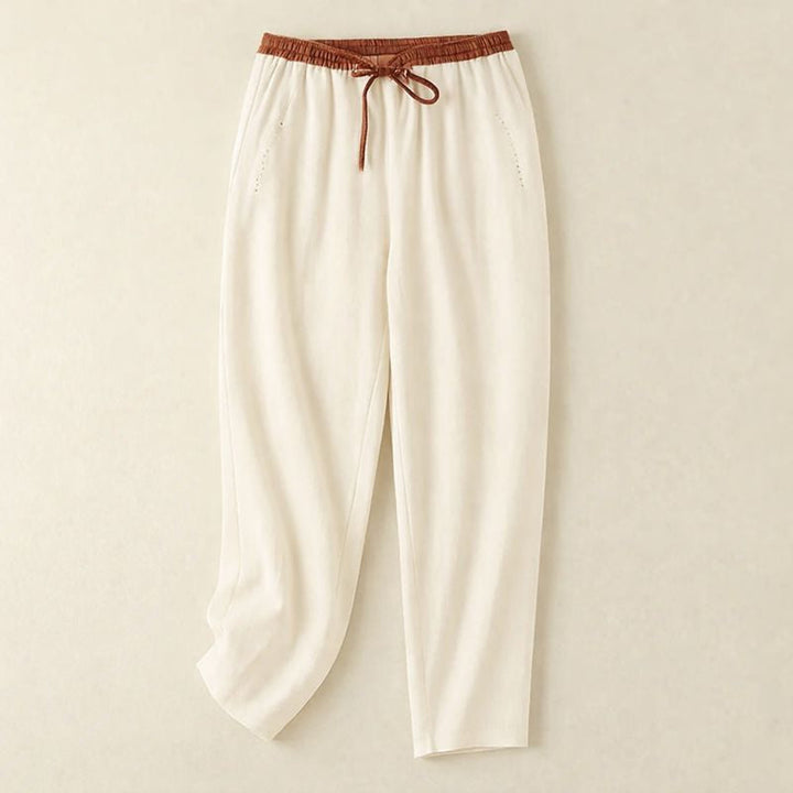 Woman wearing relaxed summer pants on a plain background.