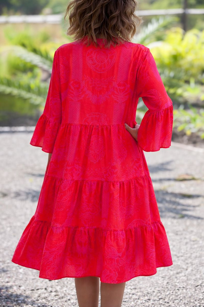 Female model posing in a loose lightweight maxi dress against a plain background back view