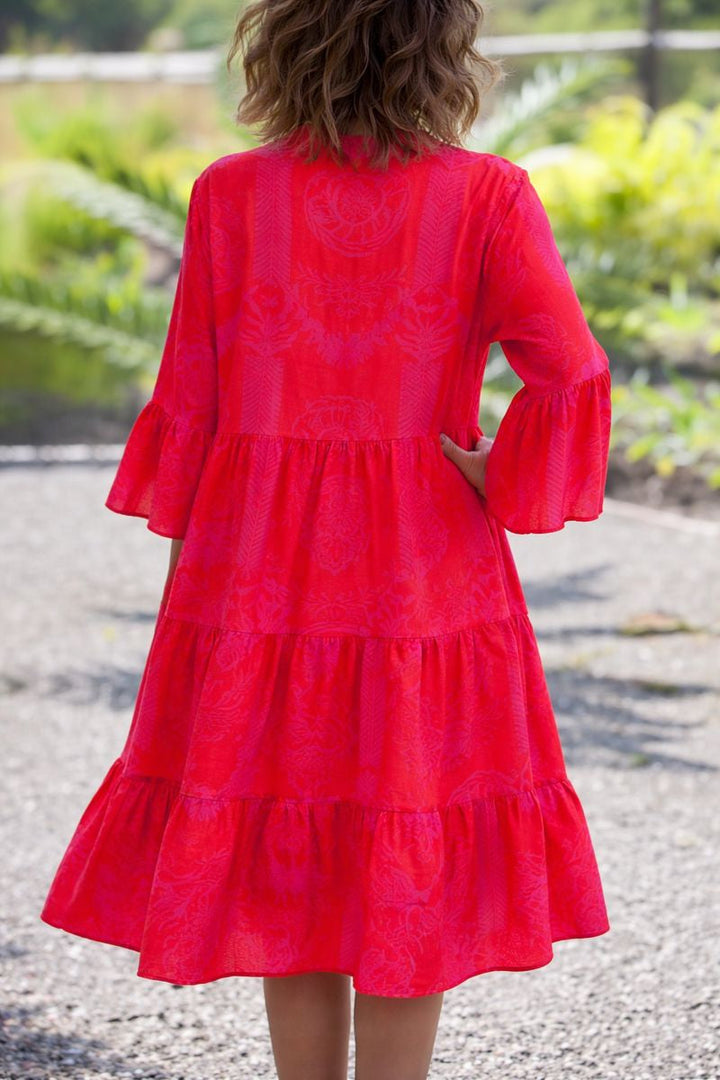 Female model posing in a loose lightweight maxi dress against a plain background back view